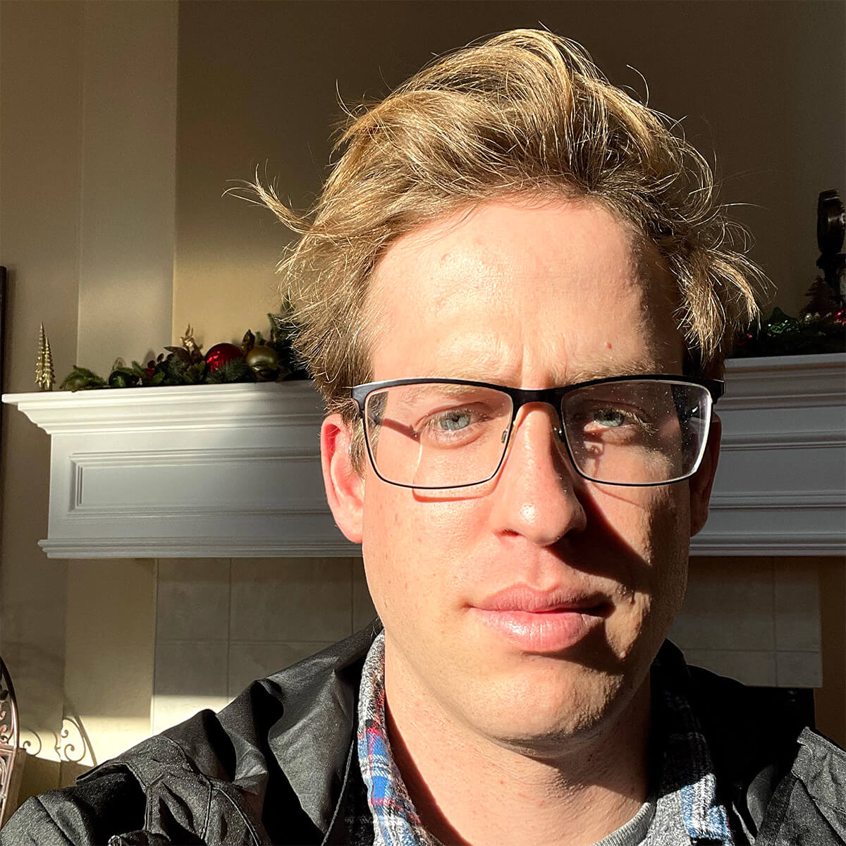 A selfie of Chuck with sunlight in his face, his hair is now flowing and looking thick.