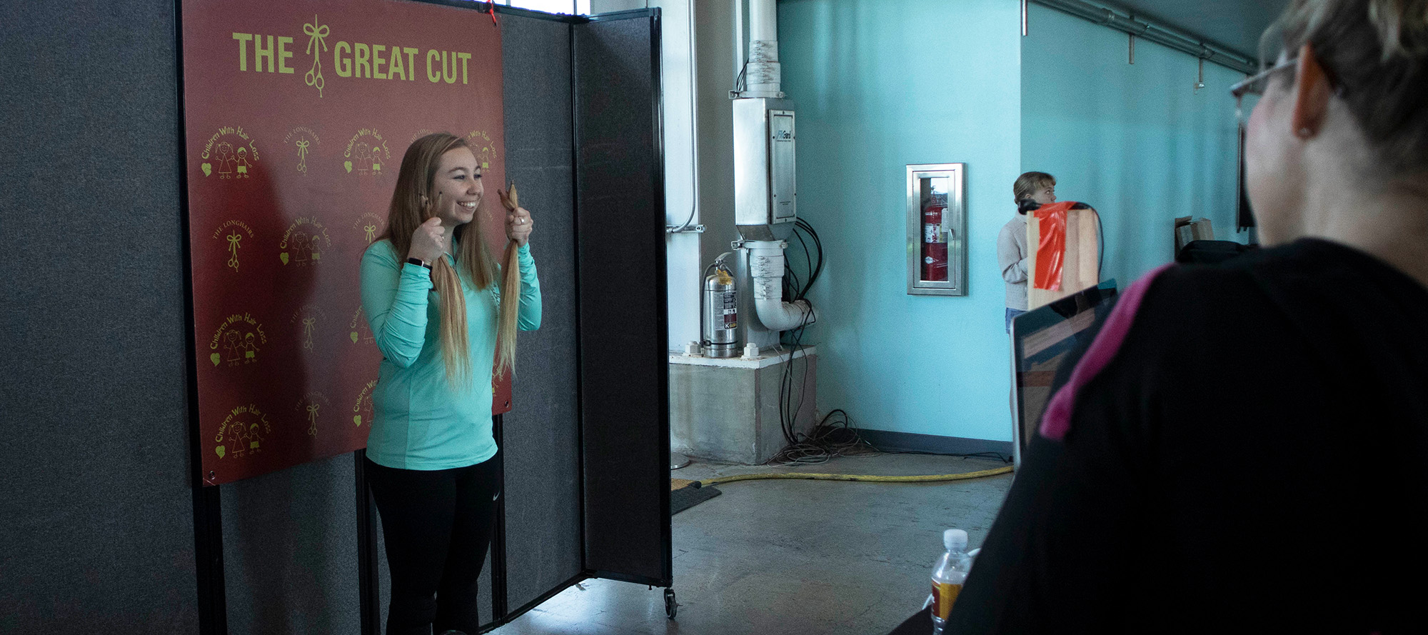 An excited hair donor at the great cut taking her after photo