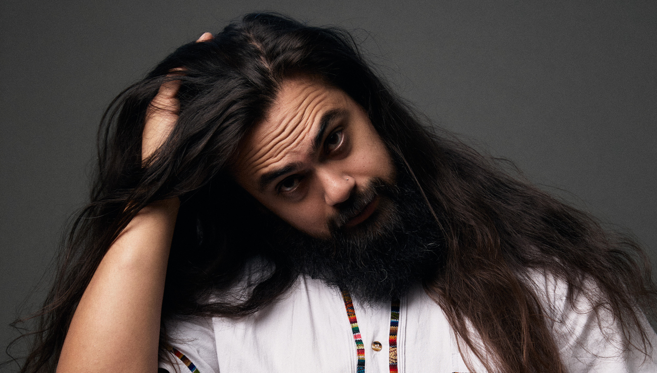 Jose Mejia Warehouse operations manager of The Longhairs holding his hair questioning why he's going to cut it after 6 years