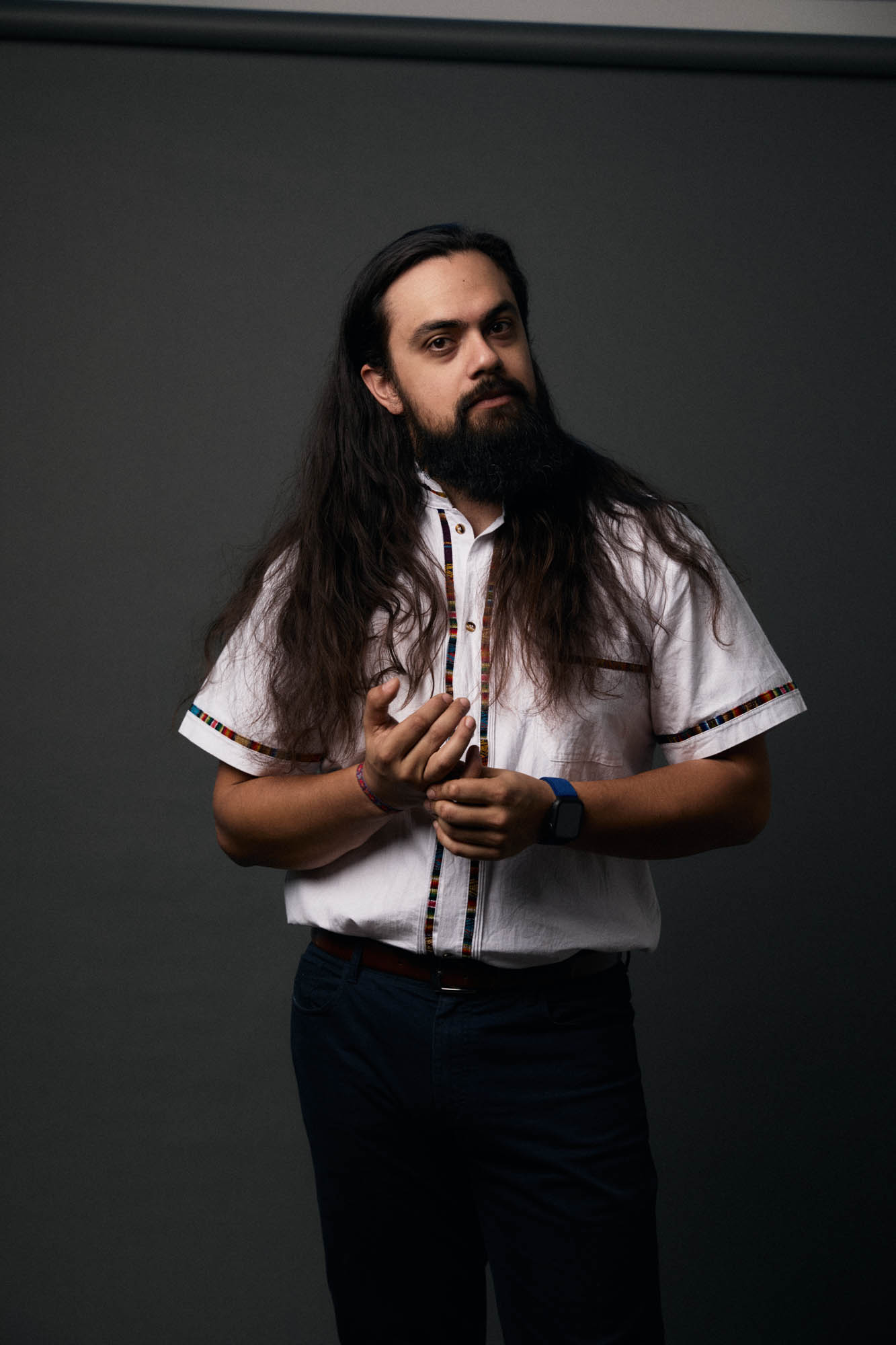 Jose Mejia contemplating the possibilities, in a studio, in a collared shirt. By Erica Joan 2024.