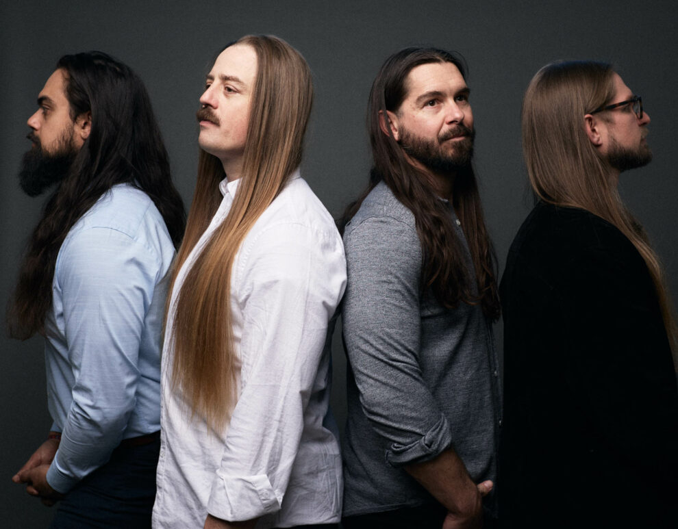 Jose Mejia and Chris Healy looking left, Lindsay Barto and Sean Horton looking right, standing in a line, in casual wear, in a studio, each looking off to the side. By Erica Joan 2024.